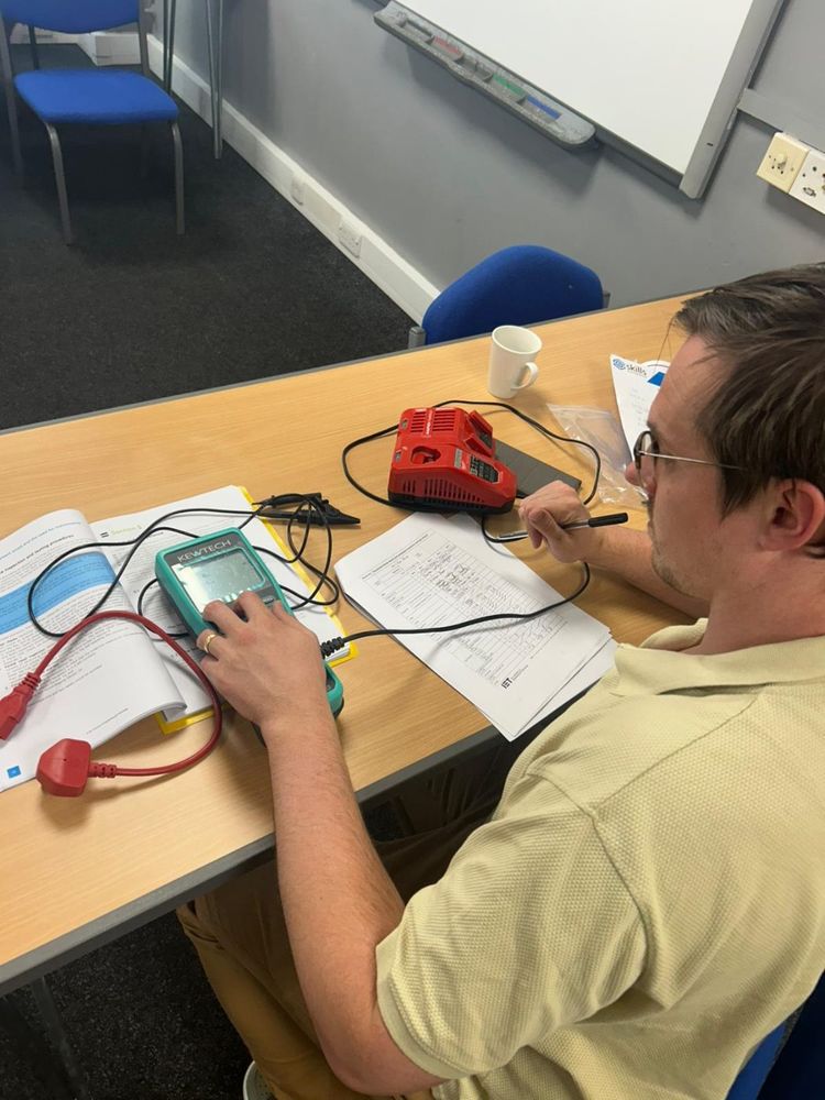 Learner getting hands-on with a PAT tester